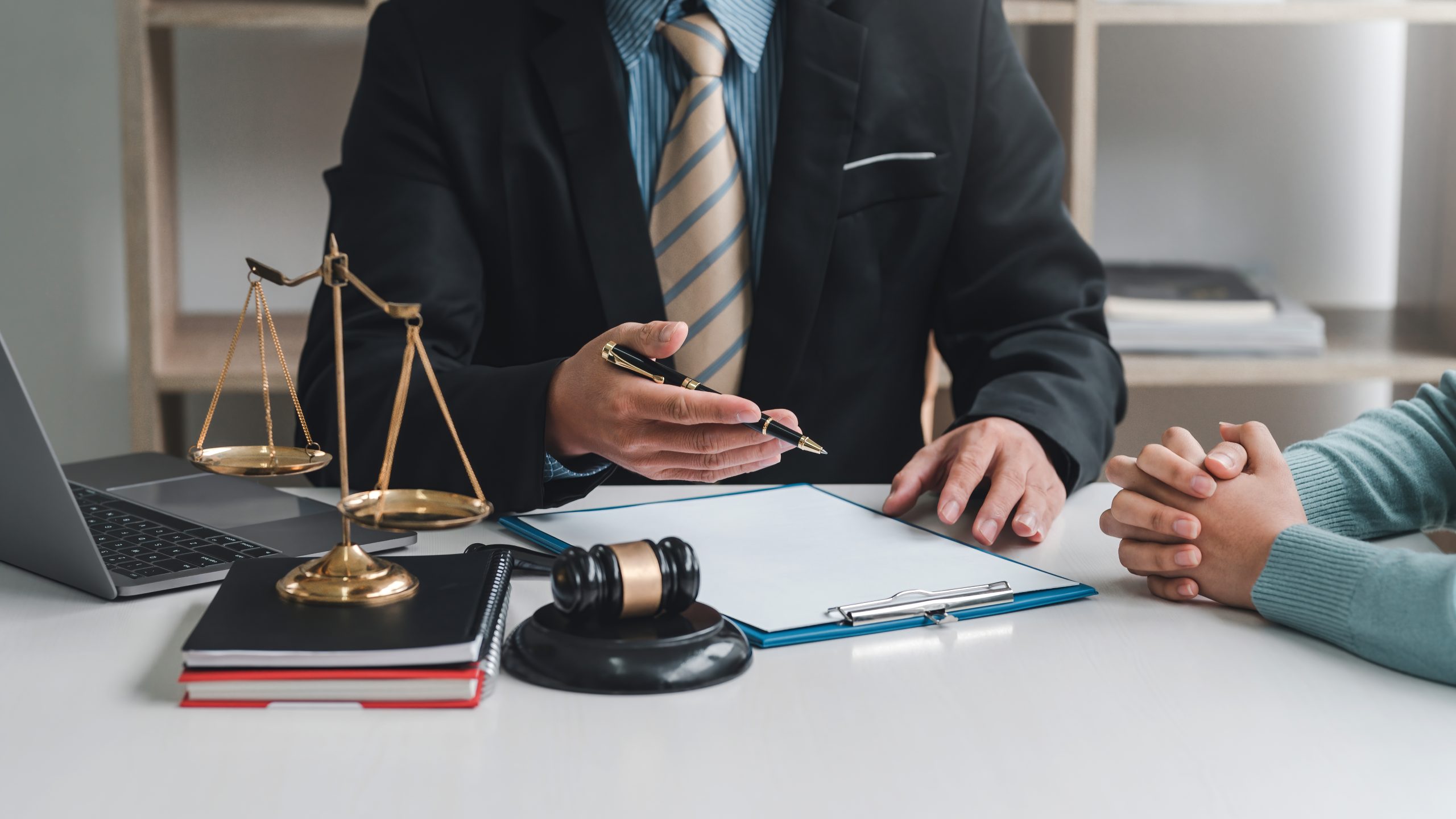 Close-up of businessman lawyer and client sitting at the office negotiating together using document